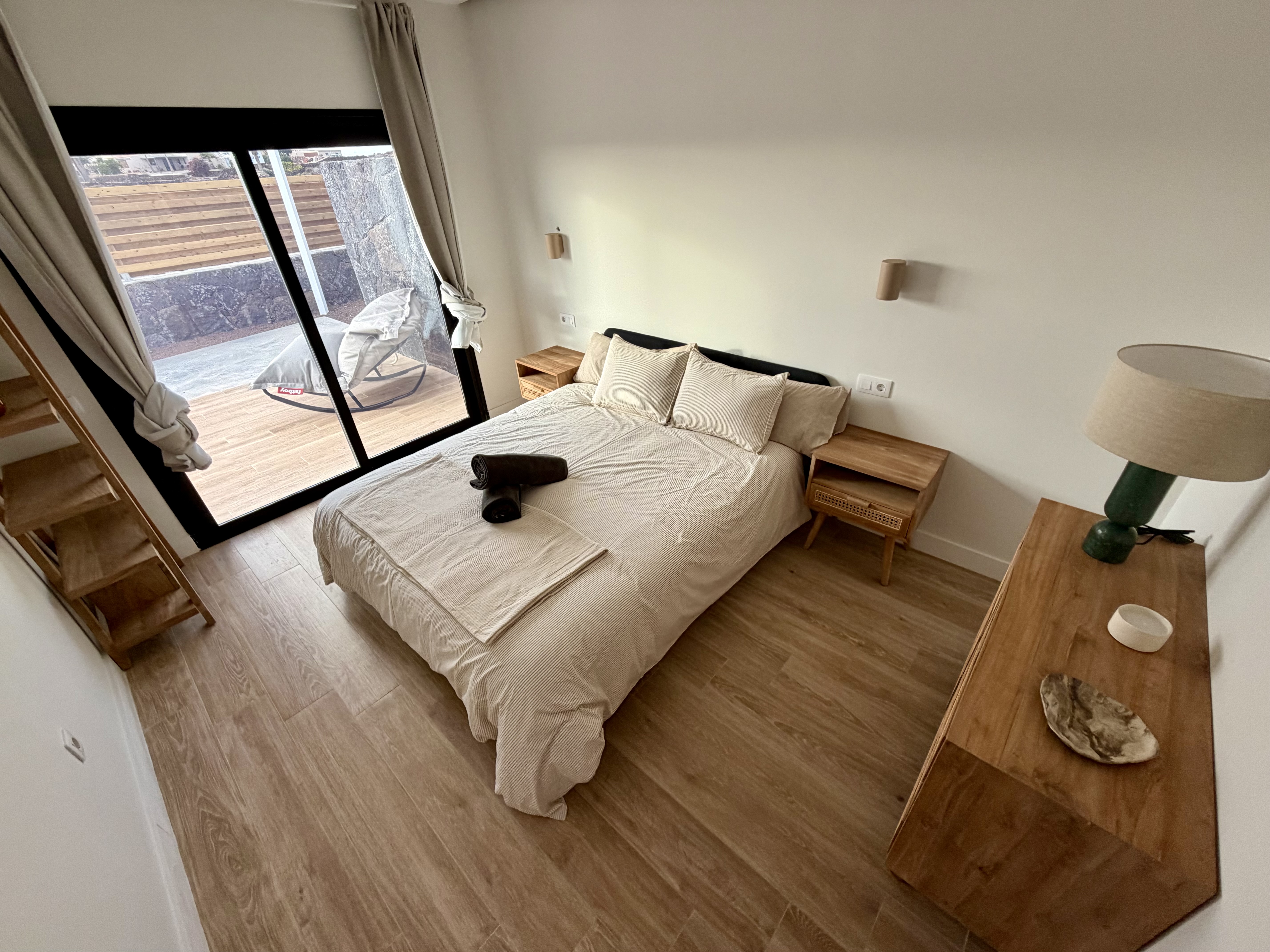 Sunlit bedroom with large bed and natural tones